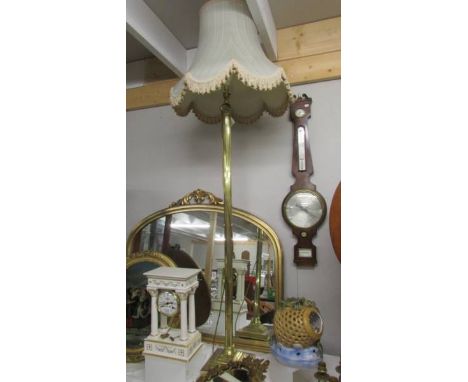 A brass standard lamp with shade.
