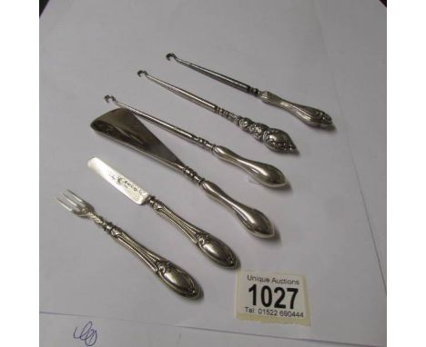3 silver handled button hooks, a silver handled shoe horn together with a small silver knife and fork.