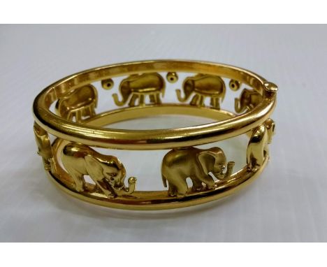 An Italian 18K yellow gold bangle with continuous openwork design of eight wrought elephants between two bands, stamped ITALY