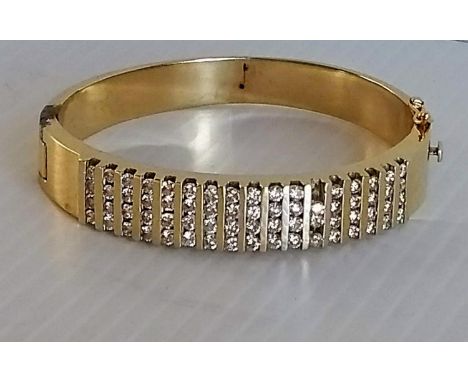 A yellow gold bangle with half-hoop 68-pave set brilliant-cut diamonds, stamped 14k, one loose stone, available, 55.82g 