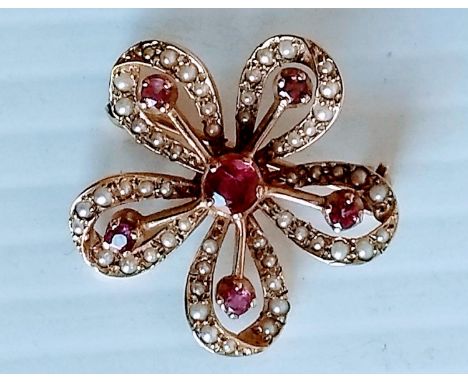 An Edwardian pearl and ruby brooch on a 9ct yellow gold setting, hallmarked, 25mm diameter approximately, 4.62g 