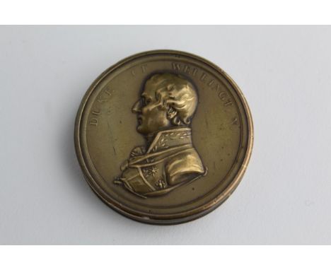 A 19th century brass circular box, the detachable lid embossed with a profile portrait of Duke of Wellington, and inscribed t