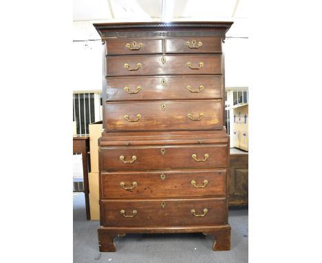 A George III mahogany chest on chest with a dentil moulded fretwork frieze, over two short and three graduated long drawers, 