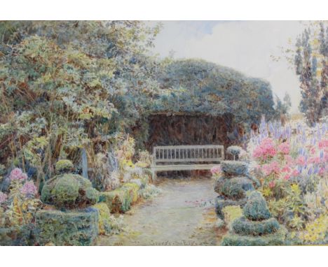 George Samuel Elgood (1851-1943) - a cottage garden in bloom, with topiary and a garden bench, watercolour signed and dated 1