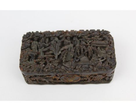 A 18th/19th century Chinese Canton tortoiseshell snuff box, deeply carved to the lid with figures amongst ferns and trees, by