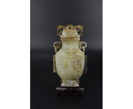 A Chinese Qing dynasty jade lidded vase of archaistic shape with twin handles, pierced phoenix heads to the lid and carved de