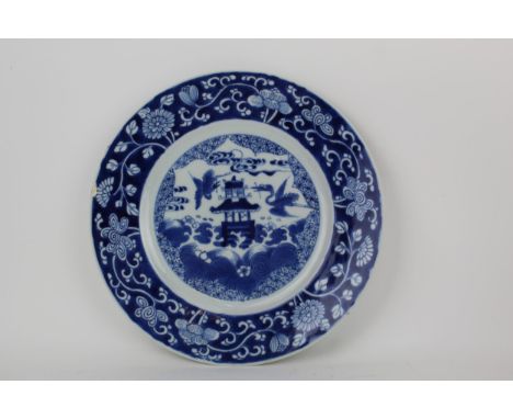A Chinese, Kangxi blue and white plate decorated with a pagoda and cranes within a floral border and stylised Artemisia leaf 