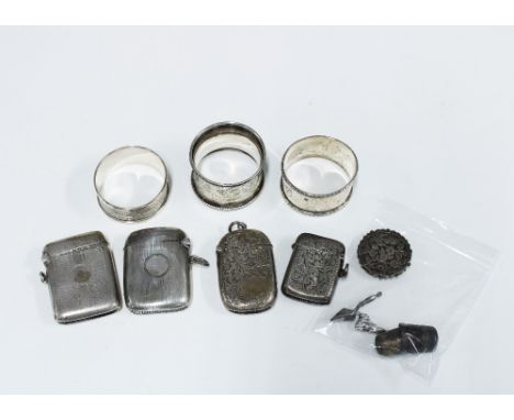 Four silver vesta case, three silver napkin rings, two silver thimbles and a silver brooch (damaged) with three small white m