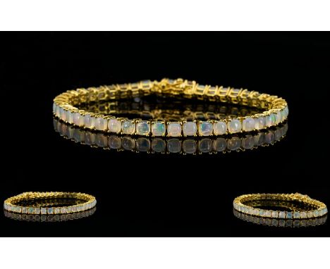 Opal Tennis Bracelet, a line of cushion cut opals, totalling 10cts, set in 14ct gold vermeil and silver, fastening with a ton