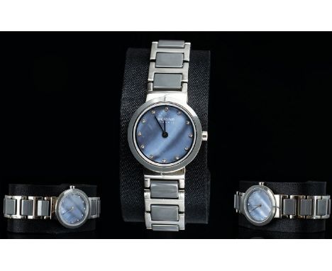 Bering - Ladies Steel and Ceramic Watch. Features Purple and Green Tones For The Mother of Pearl Dial, Ceramic Grey Bezel and
