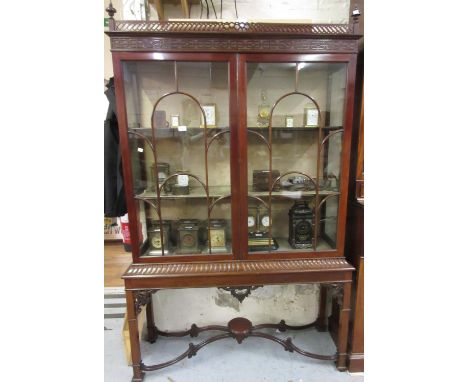 Edwardian mahogany display cabinet in Chippendale style, the pierced fretwork cornice above a blind fretwork frieze and a pai