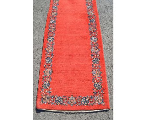 Unusual mid 20th Century central Persian runner, the plain red field with a repeating floral border, 20ft x 2ft 10ins approxi