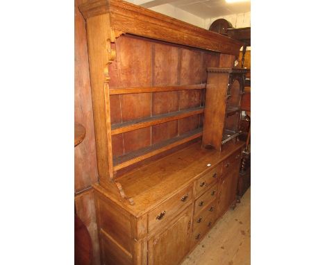 George III oak dresser, the boarded shelf back above an arrangement of six drawers and two panelled doors raised on ogee brac