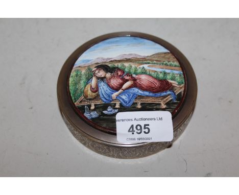 Circular Middle Eastern white metal and enamel box, the lid decorated with a female figure reclining on a day bed in a landsc