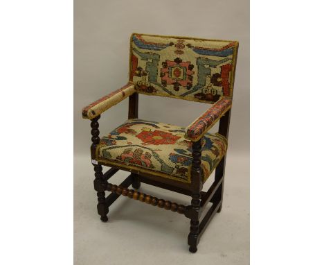 Antique oak open armchair upholstered with fragments of antique Turkish carpet, the rectangular back above an overstuffed sea