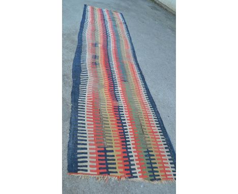 Large antique Kelim runner woven with a stylised interlocking band design, 17ft x 4ft approximately (various damages and repa