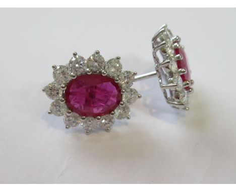Pair of 18ct white gold oval ruby and diamond cluster ear studs, the rubies of approximately 3.56ct and the diamonds approxim