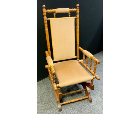 An early 20th century American bobbin turned rocking chair, upholstered back and seat panel, c.1920 