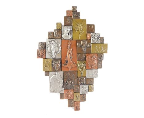 An Art Nouveau style wall plaque, formed from various metal coated blocks, relief decorated with Art Nouveau and classical fi