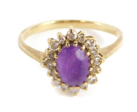 An amethyst and CZ dress ring, with central oval cut amethyst in claw setting, surrounded by halo of tiny CZ stones, in a rai