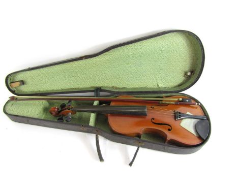 A German two piece string back violin, with label stating copy of Antonius Stradivarius, with bow, in carry case, the violin 