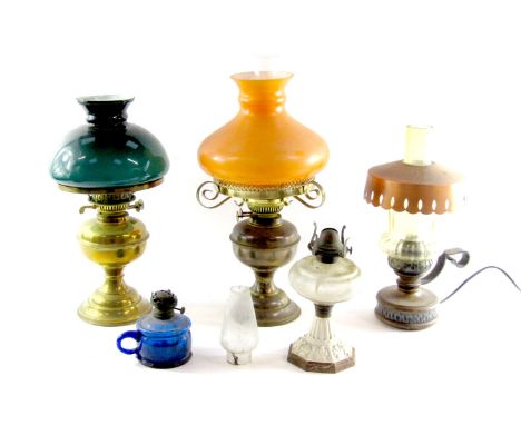 A group of Victorian and later oil lamps, comprising a Victorian oil lamp with green domed shade, a later example converted t