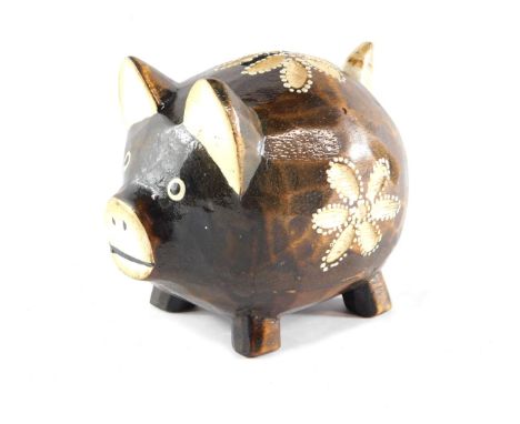 A folk art carved wooden pig money box, with floral painted decoration, 14cm high, 16cm wide. 