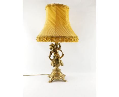 A continental brass cherub table lamp, the stem with putto holding a flower, on a floral seated base, with four out splayed l