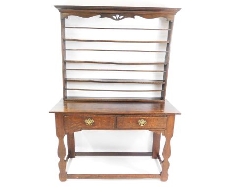 An 18thC and later oak and elm dresser, the plate rack with out swept pediment above four shelves, above a base with two frie