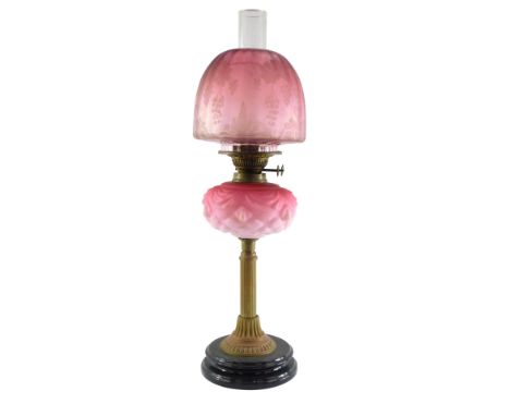 A duplex late 19thC Burmese glass and brass oil lamp, with a fluted column and moulded glass reservoir, clear glass chimney a