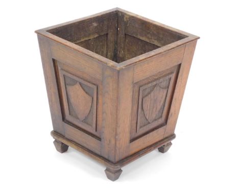 A Victorian oak planter, of tapering square section, carved with shield, raised on spade feet, 37cm high, top 32cm x 32cm. 