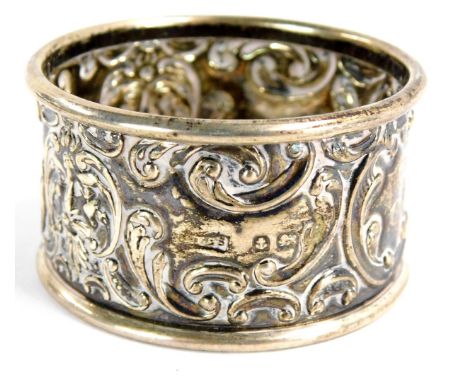 A George V silver napkin ring, with rococo scroll and mask detailing, reserve panel bearing the initials TA, Birmingham 1918,