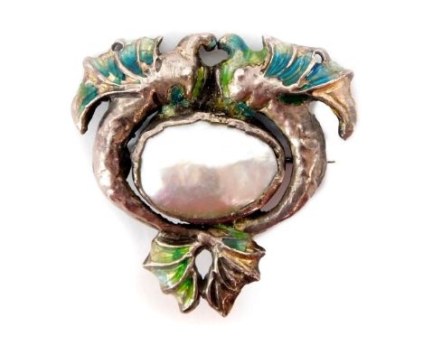 An Art Nouveau enamel pendant/brooch, depicting two fish type figures, with green and blue enamel works, on a single pin back