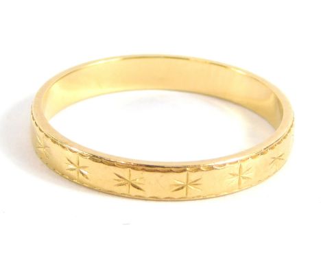 A wedding band, with star hatched design, yellow metal, unmarked, ring size N½, 2g.  