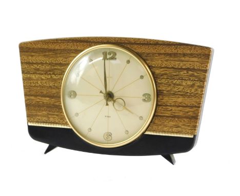 A Smiths 1950's mantel clock, the circular cream dial bearing Arabic numerals at quarters, clockwork movement, the brown bake