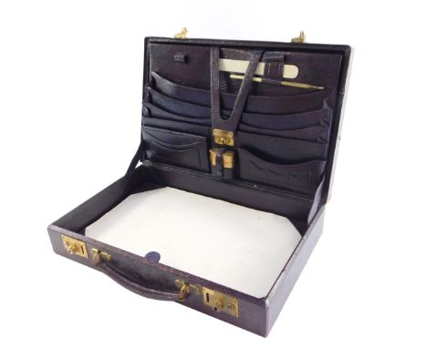 An early 20thC gentleman's red Morocco leather briefcase, with brass locks, opening to reveal a fitted interior for stationer