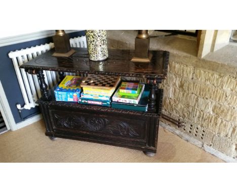 Carved oak monks bench with top shelf, chest lower, turned supports. Profuse carving to top and side panels. 106 cm long, 51 