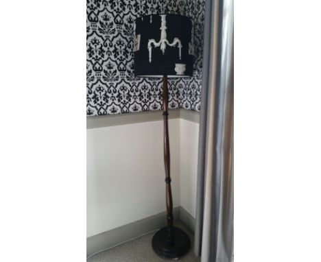 Standard lamp with black shade bearing a lamps design, dark wood stand 179 cm.  PAT tested Oct 2015, from Room 11 