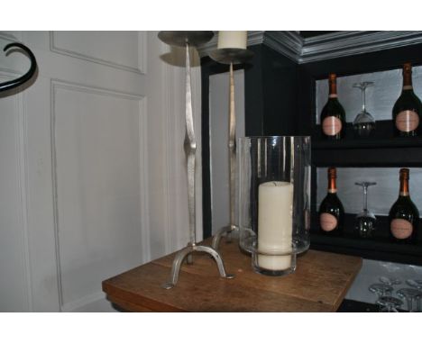 Pair tall metal candlesticks with tripod feet, 52 xm high together with glass hurricane lamp 29.5 cm high, from the Restauran