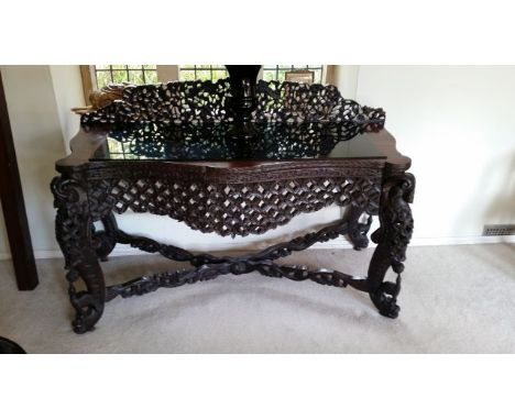 Indian hardwood carved desk, with elaborate carved fretwork back, trellis carved pelmet, carved cross-stretchers. Animal figu