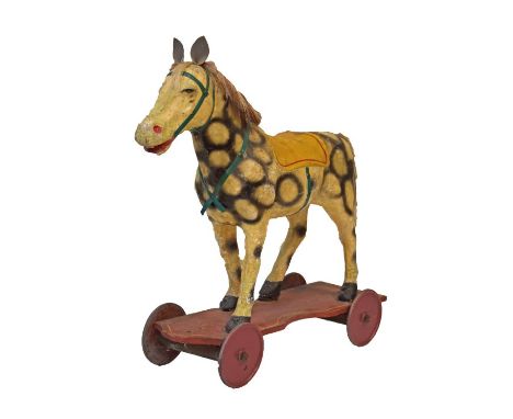 Vintage painted composition push along horse, standing on a platform base with four wheels   Condition: 