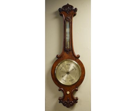 Victorian carved walnut cased wheel barometer and thermometer by West of London, having an engraved silvered dial and scale  