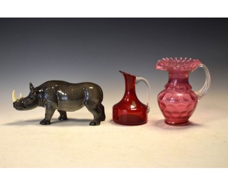 Melba Ware figure of a rhinoceros together with a cranberry glass jug and a ruby glass carafe   Condition: 