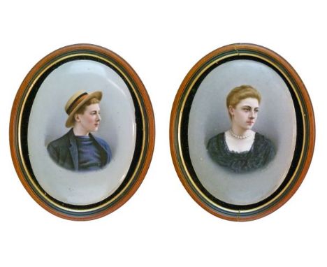 Pair of late 19th Century German porcelain oval portrait plaques, possibly Berlin, decorated with a young man wearing a straw