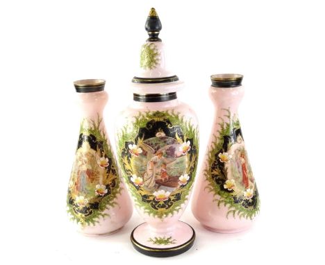 A Victorian pink opaque glass garniture, to include a vase and cover, decorated with a figure of a child etc., with elaborate