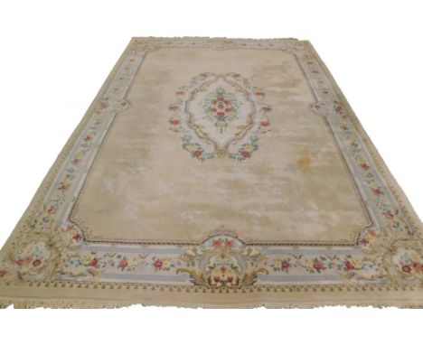 A large Indian carpet, with a central medallion decorated with flowers around a cartouche on a beige ground with one wide and