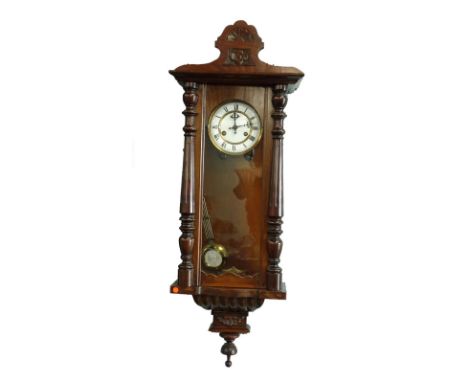 A Vienna walnut wall clock, the white enamel dial with Roman numerals, the case with reeded pilasters.