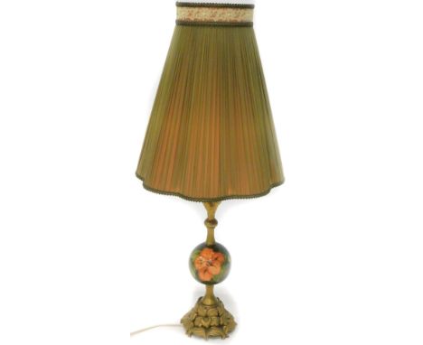A Moorcroft lamp base, with a pleated shade on gilt metal and pottery support, decorated with pink flowers with leaves on a g
