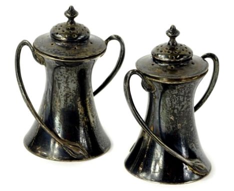 A pair of Edwardian silver two handled Art Nouveau style pepper pots, each of waisted form, with a turned finial, Sheffield 1