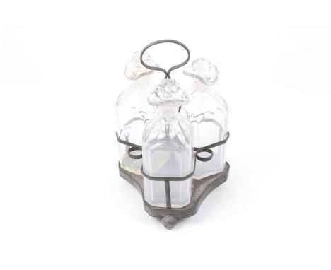 Three Georgian square cut glass decanters. With chamfered corners and fluted rims, on a silver plated stand with ball feet. H